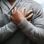 African American Man holding chest pain heart
