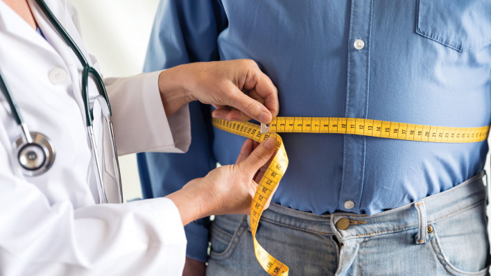 doctor measuring mans stomach