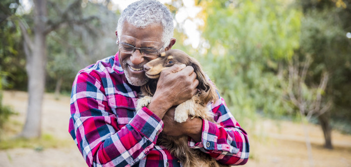 older man holding a dog