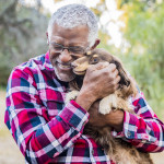 older man holding a dog