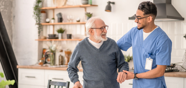 Medical worker helping his patient to move around the apartment