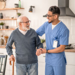 Medical worker helping his patient to move around the apartment