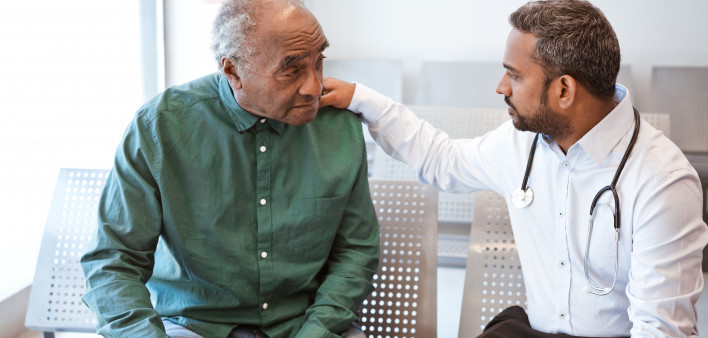 Doctor consoling sad senior male patient