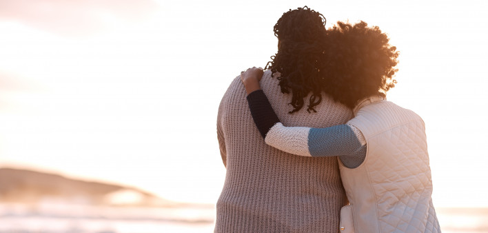 mom and daughter hugging on the beach