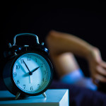 Asian man in bed suffering insomnia and sleep disorder thinking about his problem at night