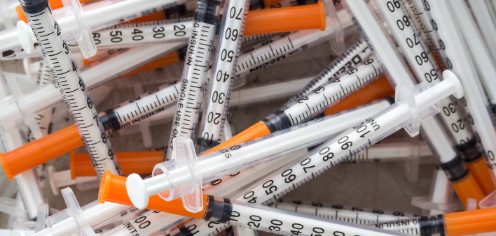 Close up of used syringes in the trash