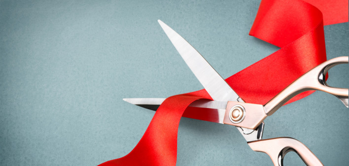 scissors cutting red ribbon