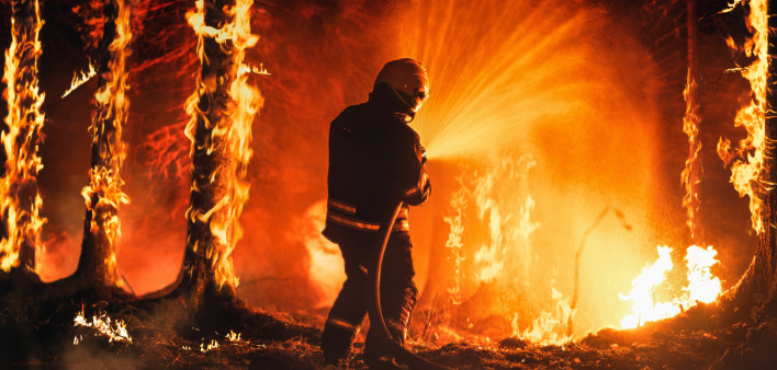 Professional Firefighter Extinguishing Large, High-Priority Part of the Forest Fire.