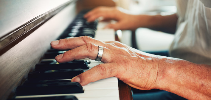 Hands, piano and senior man playing for music in living room