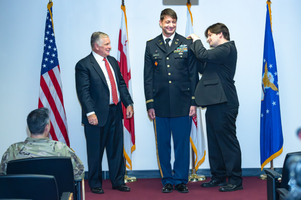 The commissioning of Nick Harrison, center, as an officer in the U.S. Army in Washington, DC, on August 5. Lambda Legal CEO Kevin Jennings, left, attends.
