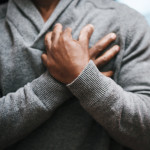 African American Man holding chest pain heart