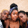 Three smiling black women hugging