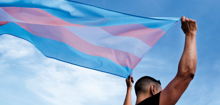 Young person with a transgender pride flag