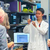 Research scientist Rong Lin gives a talk to community members touring Dr. Paul Nghiem’s lab during the Merkel CELLebration Dinner on September 9, 2024.