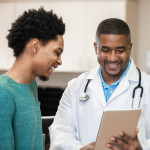 Doctor and patient looking at digital tablet in exam