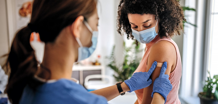 Nurse giving vaccine to patient