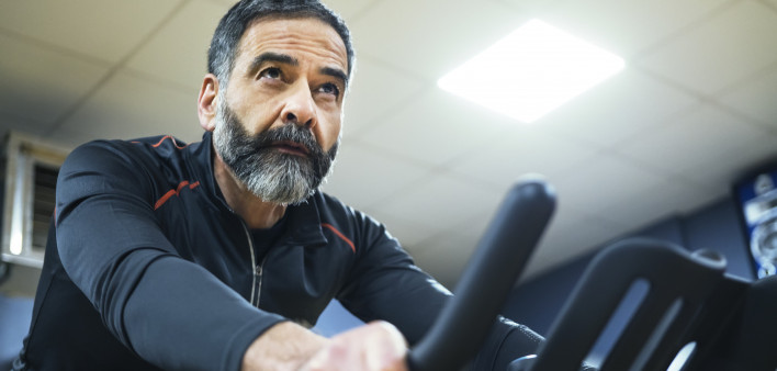 mature man exercise bike gym spin