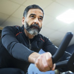 mature man exercise bike gym spin