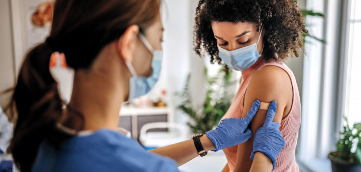 Nurse giving vaccine to patient