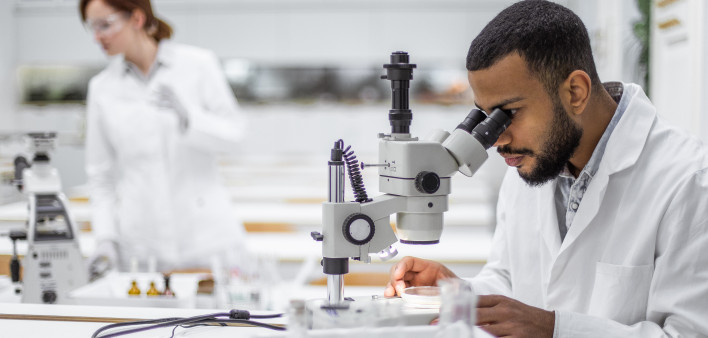 Scientist looking through the microscope stock photo Laboratory, Research, Scientist, Oncology, Cance