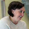 Val Beck chats from the edge of the exam table with Lindsey Davis, MD, her oncologist