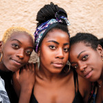 Three smiling black women hugging