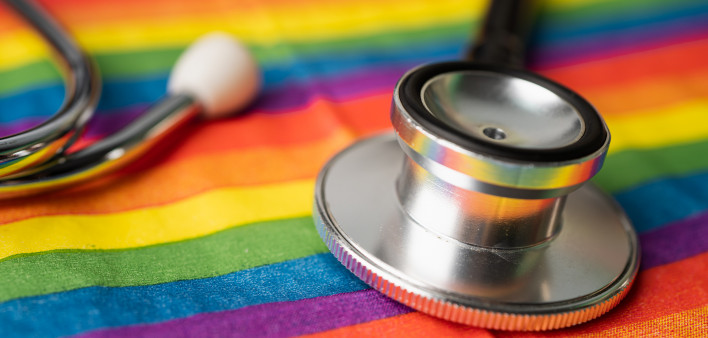 Black stethoscope on rainbow flag background,