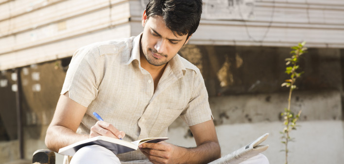 man taking notes writing in journal