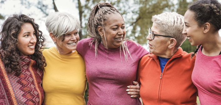 group of older women outside arm in arm smiling