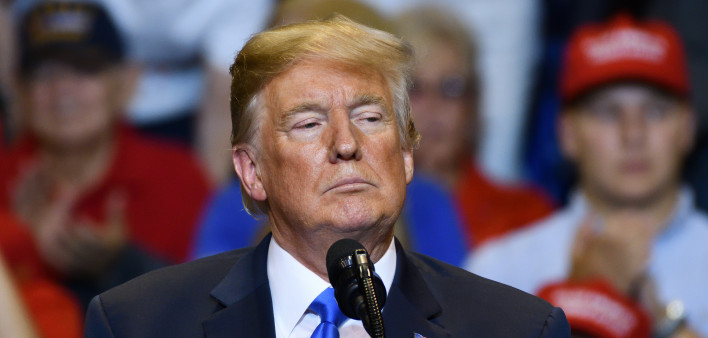 President Donald Trump with a serious look as he delivers a speech at a campaign rally held at the Mohegan Sun Arena.