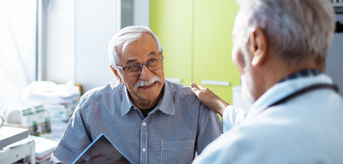 Doctor with x-rays and smiling old man patient