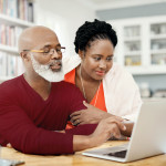 Shot of a happy mature couple using a laptop together at home