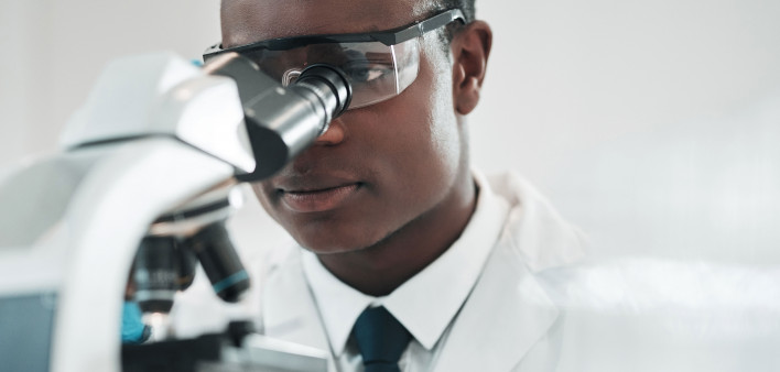 researcher looking into microscope