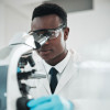 researcher looking into microscope