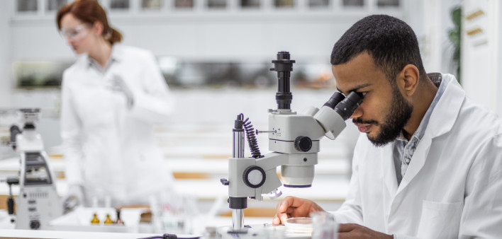 Scientist looking through the microscope stock photo Laboratory, Research, Scientist, Oncology, Cance
