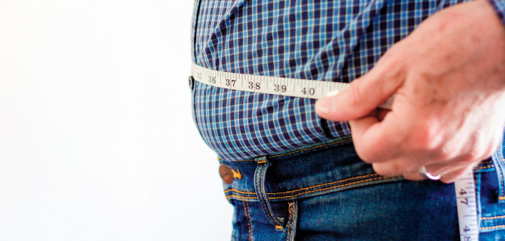 overweight man with tap measure around belly