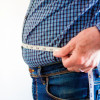 overweight man with tap measure around belly