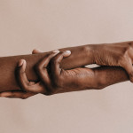 two hands holding each other black