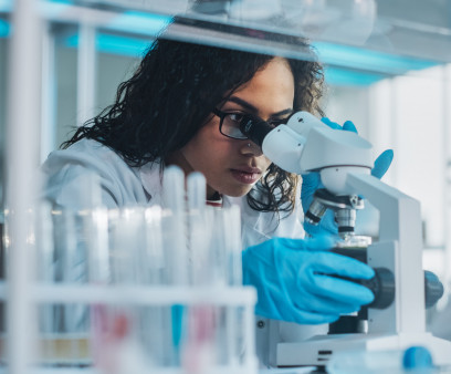 Medical Science Laboratory: Portrait of Beautiful Black Scientist Looking Under Microscope