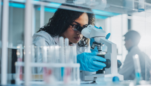 Medical Science Laboratory: Portrait of Beautiful Black Scientist Looking Under Microscope