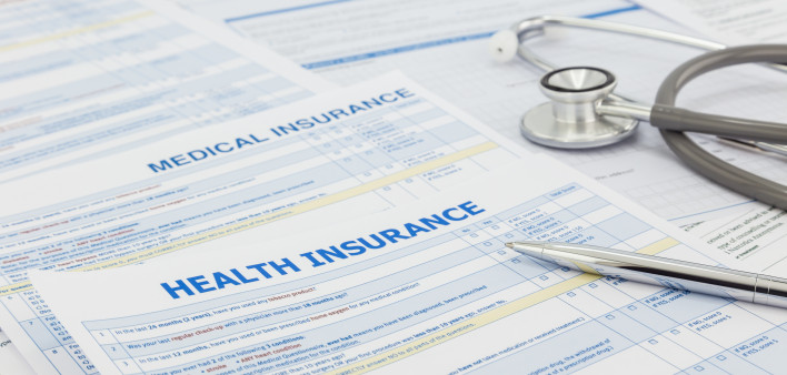 Medical insurance application, silver pen and stethoscope. Legal law contract and health insurance concepts.