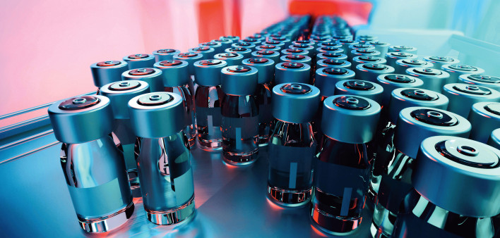 vials of vaccine on assembly line factory