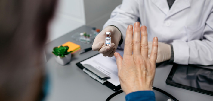 Female patient refusing the coronavirus vaccine offered by her doctor
