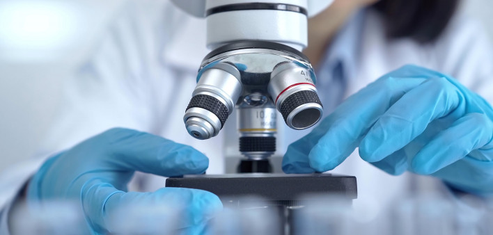 Scientist using microscope in laboratory.