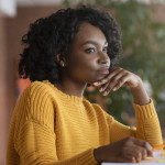 Thoughtful afro woman looking for new job online