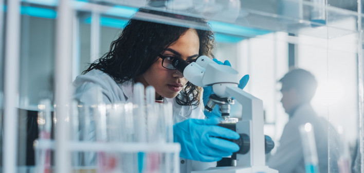 Medical Science Laboratory: Portrait of Beautiful Black Scientist Looking Under Microscope