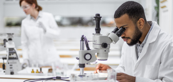 Scientist looking through the microscope stock photo Laboratory, Research, Scientist, Oncology, Cance