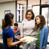 Young Latina girl and mother listen to nurse