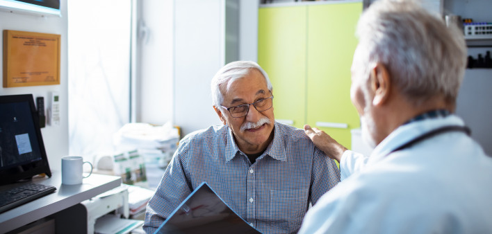 Doctor with x-rays and smiling old man patient