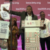 Activists at IAS 2025 protest funding cuts.